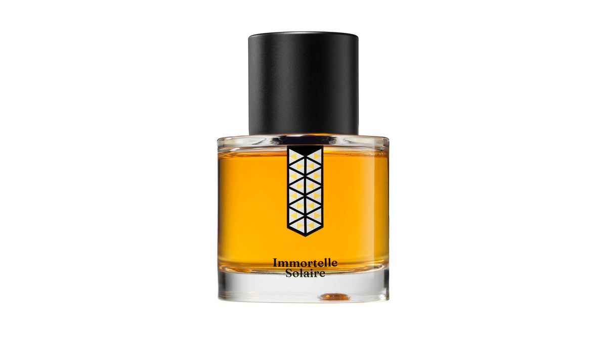 Immortelle Solaire fragrance bottle, amber glass with black cap and gold emblem